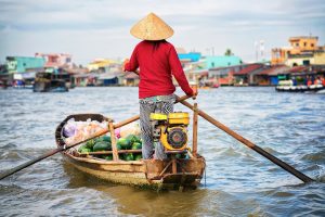 Woman in a boat selling watermelon at the Floating market at the delta Mekong in Can Tho, Vietnam